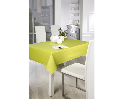 Eettafel met lichtgroen tafelkleed, servies en stoelen in een moderne keuken