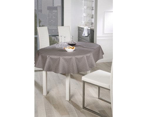 Eettafel met grijs tafelkleed en serviesgoed in een lichte omgeving