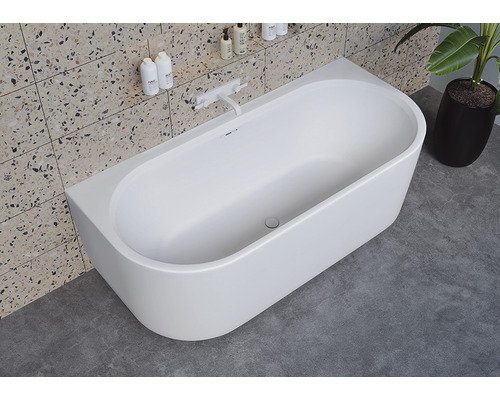 Vrijstaand bad in moderne badkamer met betegelde wand en kamerplant