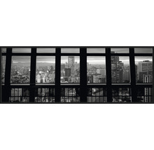 Zwart-witfoto met uitzicht door een raam op een stad