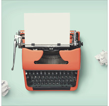 Oranje typemachine met een vel papier en propjes papier