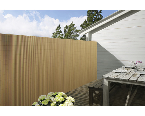 Buitenkant met privacyscherm, terrastafel en bloemen