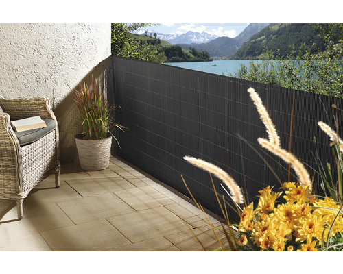 Terras met privacyscherm, rotan stoel en planten