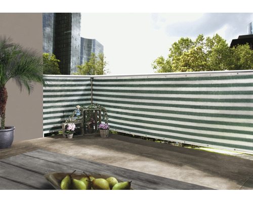 Scene van een balkon met privacyscherm, versierd met bloemen en een palmboom in een pot