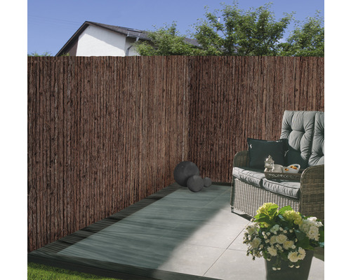 Terrasscène met privacyhek van natuurlijke materialen en zitgedeelte