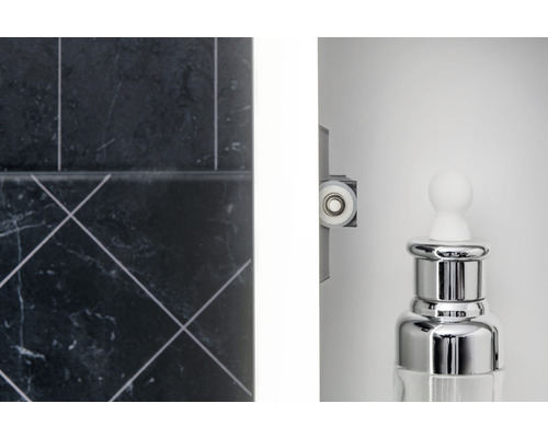 Detailopname van een badkamer met tegels, douchecabinerol en een dispenser