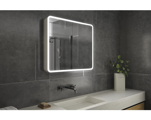 Badkamer met verlichte spiegelkast, wastafel en kraan.