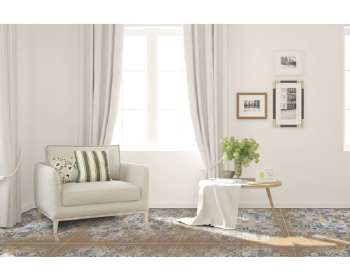 Woonkamer met fauteuil, tafel en vloertegels met patroon voor een gezellige sfeer.