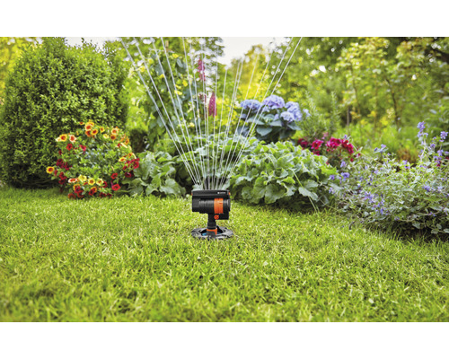 Tuin met gazonsproeier in werking