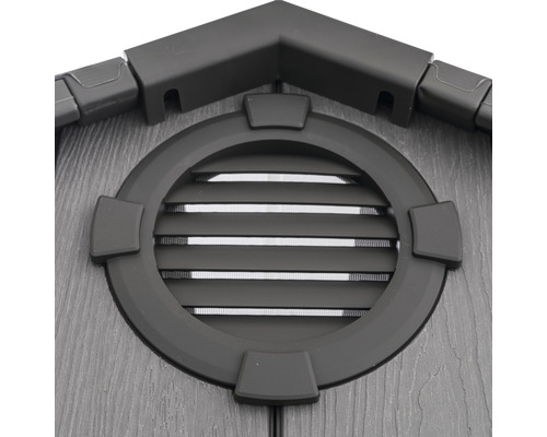 Detailopname van een tuinhuis met een rond raam en ventilatieroosters