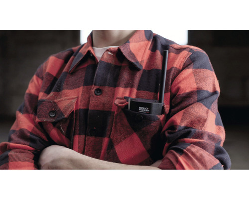 Een persoon met een veiligheidsapparaat voor alleenwerkers in zijn of haar zak.