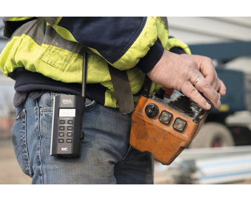 Close-up van een man met radio en kraanbediening