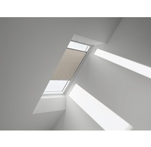 Dakvenster met gedeeltelijk gesloten plissé in een lichte kamer.