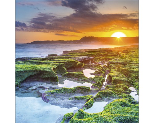 Landschapsfoto met rotsen, vegetatie en zonsondergang aan zee