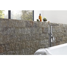 Badkamerontwerp met natuurstenen muur, bad en armaturen
