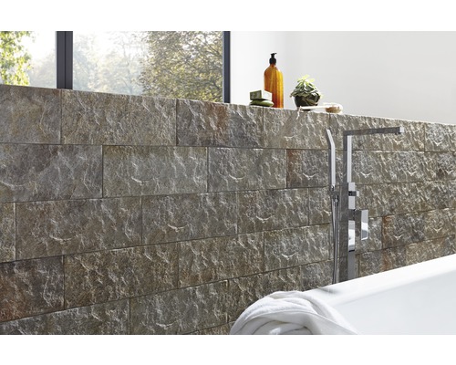 Badkamerontwerp met natuurstenen muur, bad en armaturen