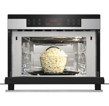 Open magnetron met een kom popcorn erin