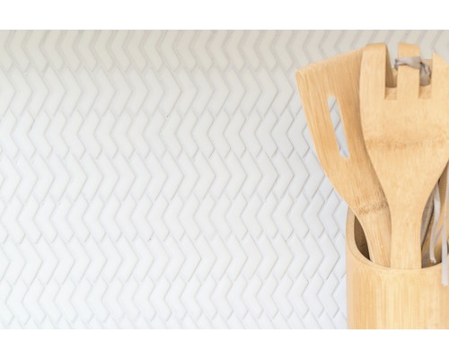 Keukengerei van bamboe in houder voor een witte achtergrond