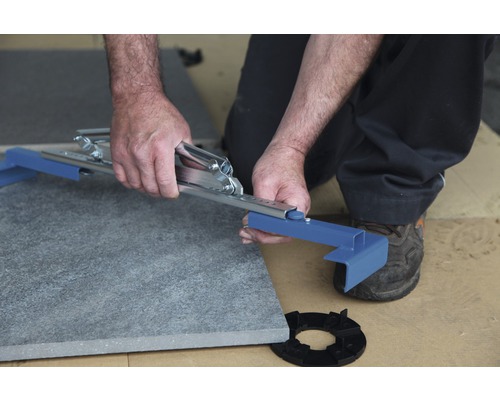 Man snijdt stenen plaat met gereedschap op onderconstructie.