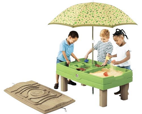 Kinderen spelen aan een zand- en watertafel met parasol.