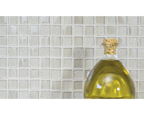 Glazen mozaïektegels met een fles olie op de voorgrond