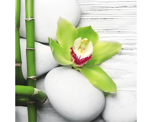 Decoratieve schikking met bamboe, witte stenen en orchidee