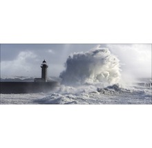 Een vuurtoren aan een kust met hoge golven.