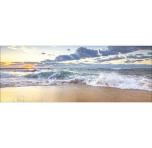 Golven op het strand bij zonsondergang