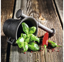 Vijzel met stamper, basilicum en chilipeper op een houten tafel