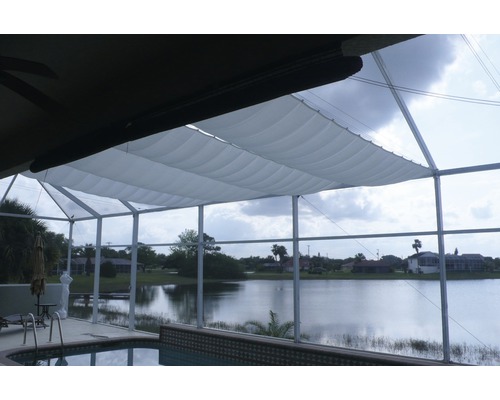 FLORACORD Schaduwdoek harmonica waterafstotend zilvergrijs 96x220 cm Scène met een stoffen zonnescherm boven een terras met zwembad en uitzicht op een meer.