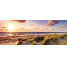 Zonsondergang op het strand met duinen en zee