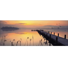 Foto van een meer met steiger bij zonsopgang