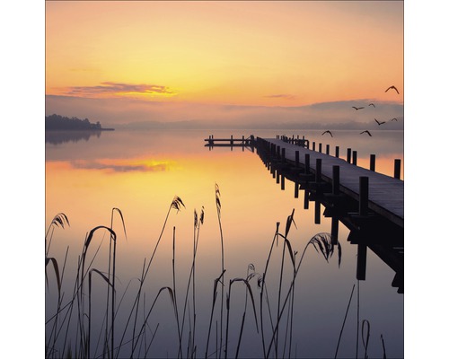 Houten steiger aan de oever van het meer bij zonsopgang
