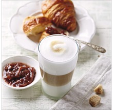 Latte macchiato in glas met croissant en jam