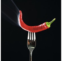 Een rode chilipeper ligt op een vork, er komt rook vanaf.