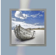 Wanddecoratie met een oude boot aan de kust onder een blauwe hemel