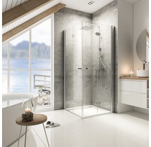 Moderne badkamer met douchecabine, wastafel en ligbad voor een raam met uitzicht op het meer.