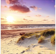 Strandlandschap met zee, zand en duin bij zonsondergang