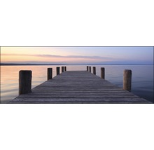 Houten steiger leidt naar rustig water bij zonsondergang