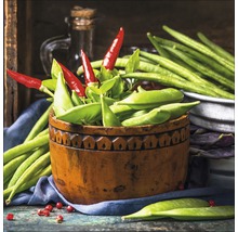 Arrangement met erwtenpeulen, groene bonen en rode chilipepers in houten schaal