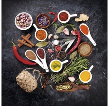 Arrangement van diverse specerijen, kruiden en ingrediënten op een donkere achtergrond.