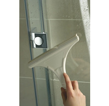 Hand veegt met een douchewisser een douchewand schoon