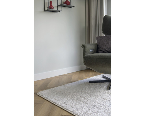 Woonkamer met fauteuil, tapijt en wandplanken