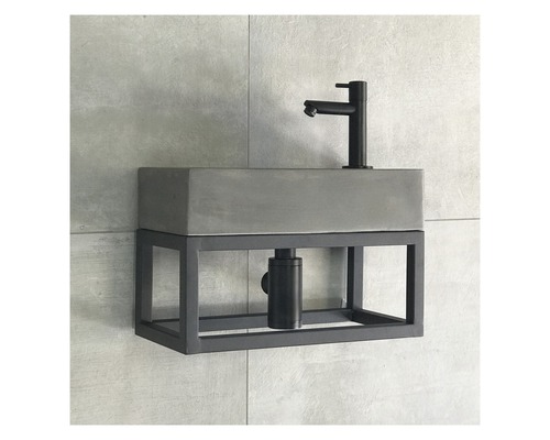 Wastafel met betonnen waskom en metalen frame aan de muur
