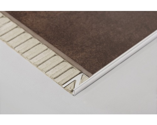 Metalen tegelprofiel op een bruine tegel