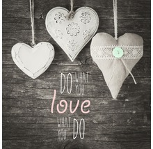 Decoratieve harten hangen voor een houten oppervlak met de tekst ''Doe wat je liefhebt''