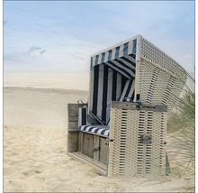 Strandstoel van rotan met gestreepte stoffen bekleding op het strand