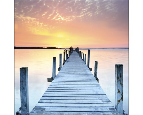 Houten steiger over water bij zonsondergang
