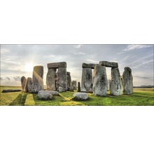 Stonehenge stenen cirkel op een groen veld onder een bewolkte hemel.