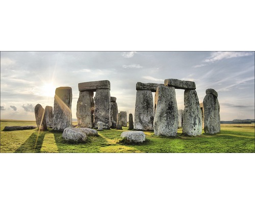 Stonehenge stenen cirkel op een groen veld onder een bewolkte hemel.